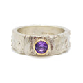 textured silver ring with a purple sapphire set in gold