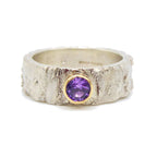 textured silver ring with a purple sapphire set in gold