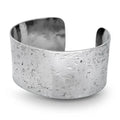 Silver handmade textured cuff bracelet on a white background