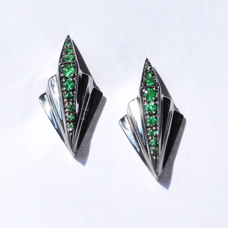 Front view of the Art Deco sterling silver earrings featuring green tsavorite garnets and a black geometric design.