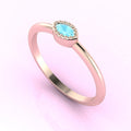 Angled perspective of an 18ct rose gold ring with a horizontal marquise aquamarine and textured milgrain edges.