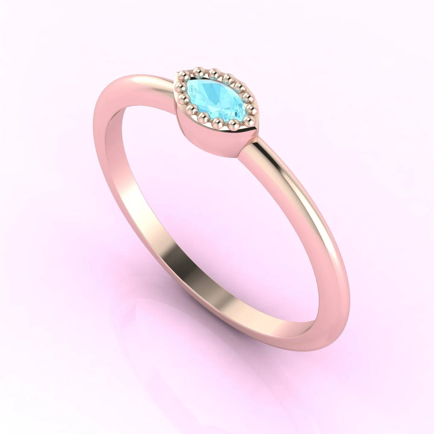 Angled perspective of an 18ct rose gold ring with a horizontal marquise aquamarine and textured milgrain edges.