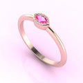 Angled view of an 18ct rose gold ring with a horizontal marquise pink sapphire and delicate milgrain edges.