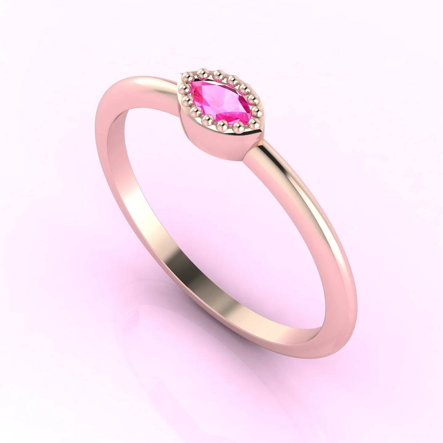 Angled view of an 18ct rose gold ring with a horizontal marquise pink sapphire and delicate milgrain edges.