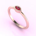 Angled view of an 18ct rose gold ring with a horizontal marquise ruby and fine milgrain textured edges.