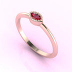 Angled view of an 18ct rose gold ring with a horizontal marquise ruby and fine milgrain textured edges.