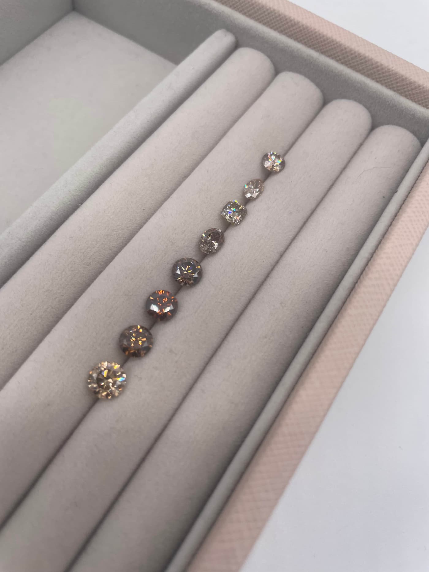 Loose oval champagne diamonds on a tray for client selection for a bespoke ring.