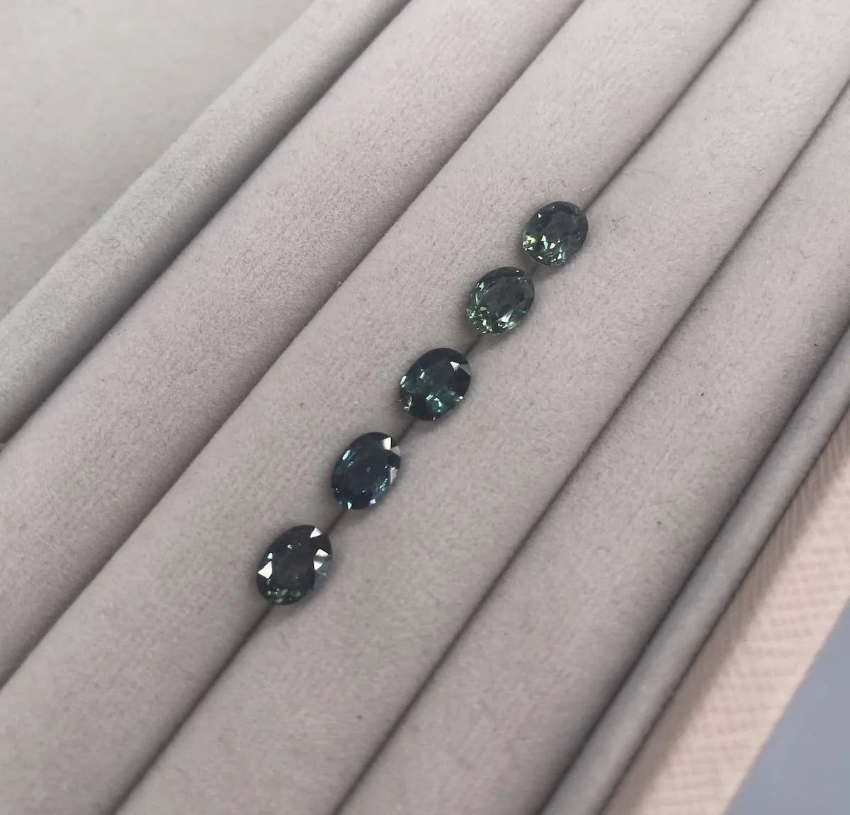 oval teal sapphires, loose on velvet tray for client selection for a bespoke engagement ring