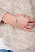 Close-up shot of the  fine silver Splat bracelet worn on a wrist, demonstrating the delicate fit and drape.