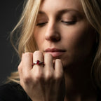 Maisie oval ruby and diamond engagement ring worn on hand in 18ct white gold, showing the vivid oval ruby centre stone with diamond shoulders, handmade in our London studio