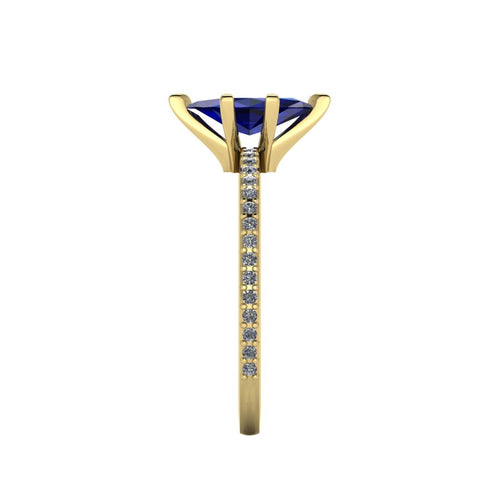Close-up side view of the 18ct yellow gold Amoret ring highlighting the secure claw setting for the blue sapphire and the grain-set shoulder diamonds.