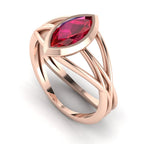 Infinity marquise ruby ring in 18ct rose gold, profile view showing the deep red ruby set in the sculptural wrap-around band, alternative engagement ring handmade in our London studio