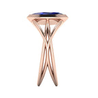 Infinity marquise blue sapphire ring in 18ct rose gold, side profile showing the elegant low-set marquise sapphire and sculptural band, handmade in London