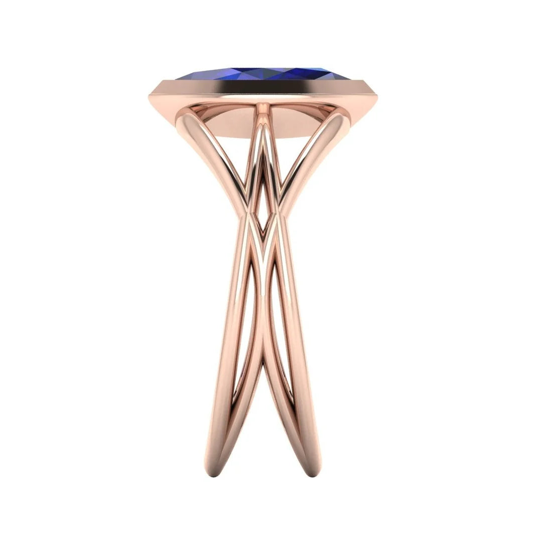 Infinity marquise blue sapphire ring in 18ct rose gold, side profile showing the elegant low-set marquise sapphire and sculptural band, handmade in London
