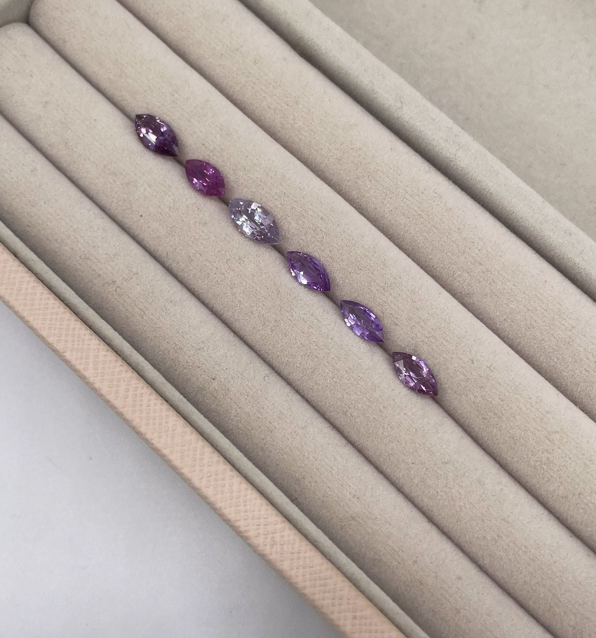 Tray of marquise-cut violet, lavender and purple sapphires for bespoke engagement rings at Nude Jewellery.