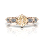 Rose gold ring with a large champagne diamond and small white marquise diamonds on a white background