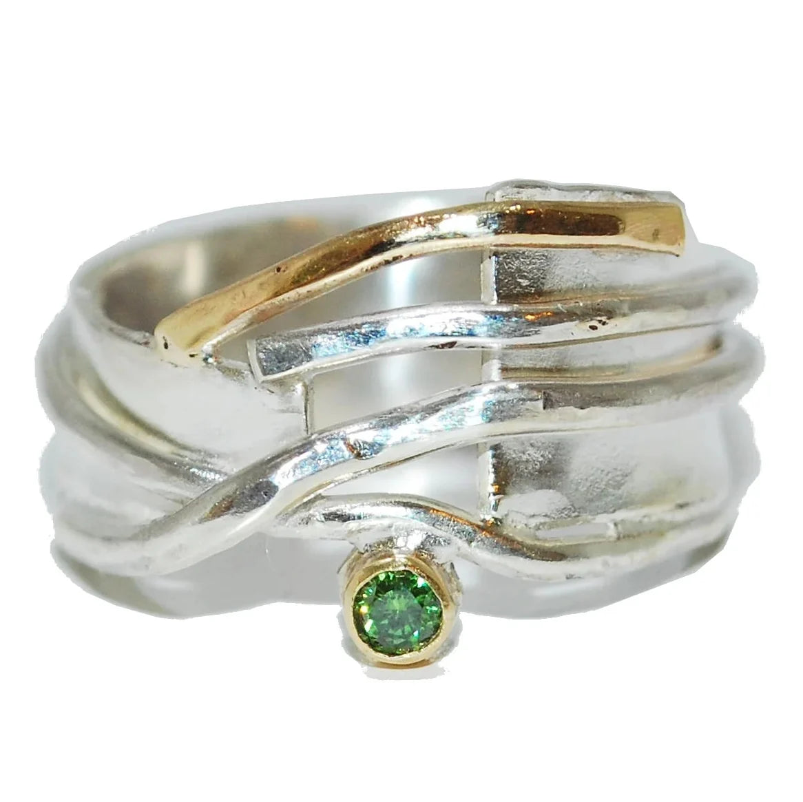 A multi-layered wave-style silver ring featuring textured silver bands, polished gold-toned accents, and a small round green sapphire gemstone, shown on a plain white background.