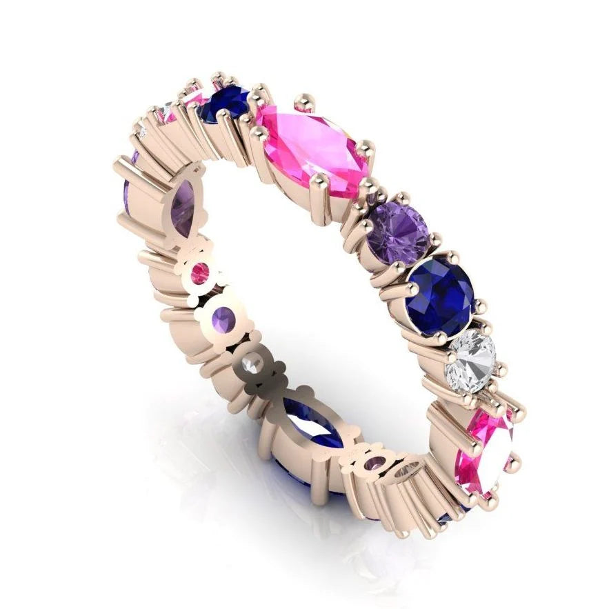 An angled profile view of the Allsorts eternity ring featuring a vibrant mix of pink, blue, and yellow gemstones in 18ct rose gold.