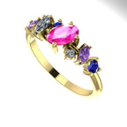 An angled view of the 18ct yellow gold ring highlighting the play of light across the different gemstone facets.