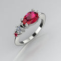 Pear shaped ruby, diamond and ruby accent asymmetrical Comet engagement ring in 18ct white gold, angled view showing diamond and ruby accents