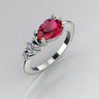 Pear shaped ruby and two diamond asymmetrical Comet engagement ring in 18ct white gold, angled view showing two diamond accents