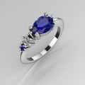 Pear shaped blue sapphire and diamond asymmetrical Comet engagement ring in 18ct white gold, angled view