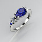 Pear shaped blue sapphire and diamond asymmetrical Comet engagement ring in 18ct white gold, angled view