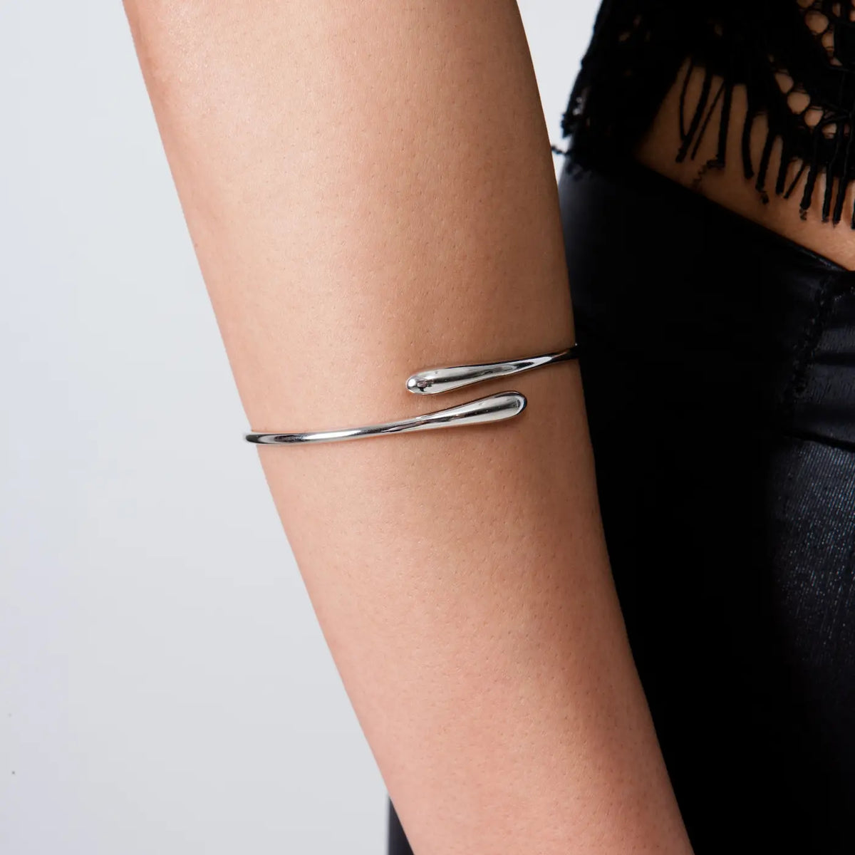 cuff on model in black outfit — sleek sterling silver open cuff with twin droplet ends