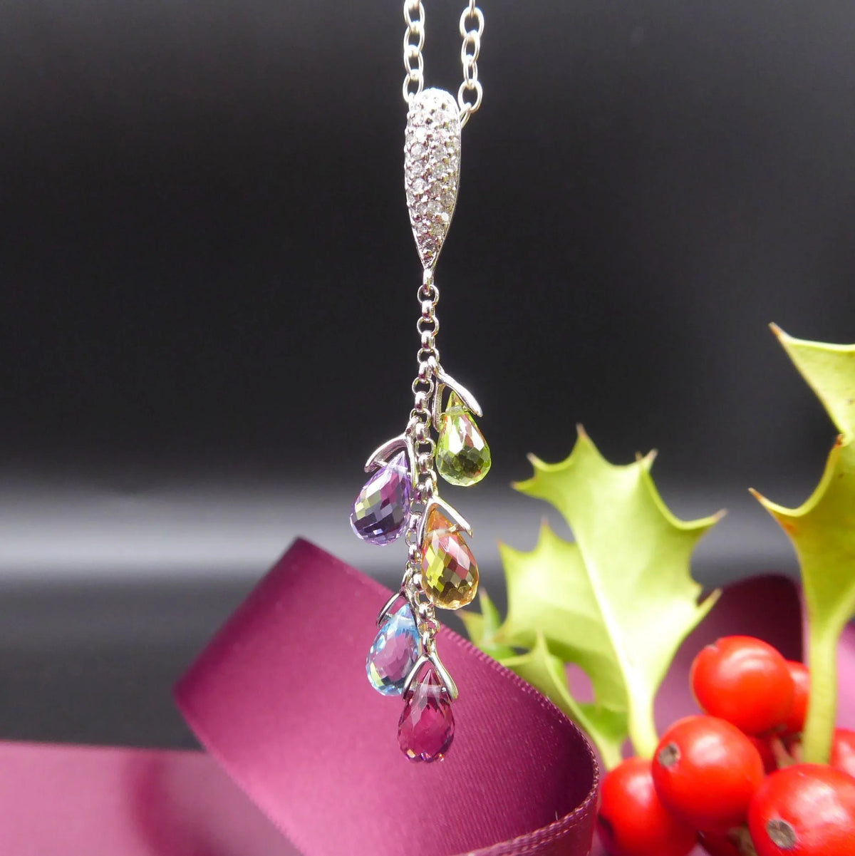 Front view of the 18ct yellow gold necklace featuring a cluster of pastel briolette gemstones and a brilliant-cut diamond.