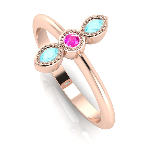 Angled view of an 18ct rose gold trilogy ring featuring pink sapphire and aquamarines with fine milgrain textures.