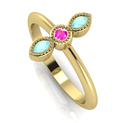 Angled view of an 18ct yellow gold trilogy ring featuring a pink sapphire and aquamarines with fine milgrain textures.