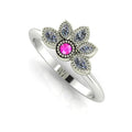 Angled perspective of a pink sapphire and diamond cluster ring in white gold featuring fine milgrain textured edges.