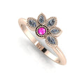 Angled perspective of a pink sapphire and diamond cluster ring in 18ct rose gold with fine milgrain textured edges.