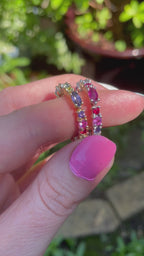 A high-definition video of the Allsorts eternity ring rotating to show the vibrant transition from cool blue sapphires to warm pink and red gemstones in 18ct rose gold