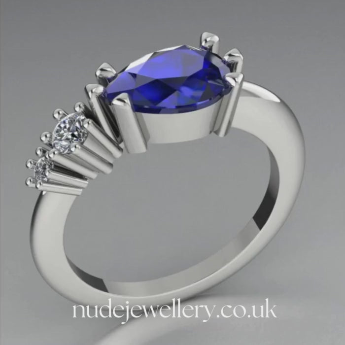 Pear shaped blue sapphire and two diamond asymmetrical Comet engagement ring in 18ct white gold, 360 degree view