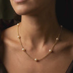 Pearl and gold chain necklace featuring seven ivory freshwater pearls spaced along an 18ct yellow gold chain.