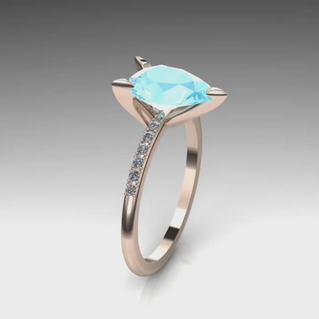 Video of the Calista aquamarine ring in 18ct rose gold, capturing the soft pastel-blue shimmer of the 2-carat pear centre stone and its brilliant white diamond shoulders.