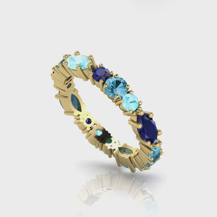 360-degree video of the True Blue eternity ring in 18ct yellow gold, showcasing a vibrant combination of tonal blue sapphires and aquamarines in a bespoke hand-finished setting
