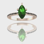 A 360-degree video of the Amoret green tourmaline engagement ring in 18ct rose gold. The footage highlights the deep green facets of the marquise tourmaline and the dark sparkle of the black diamond shoulders.
