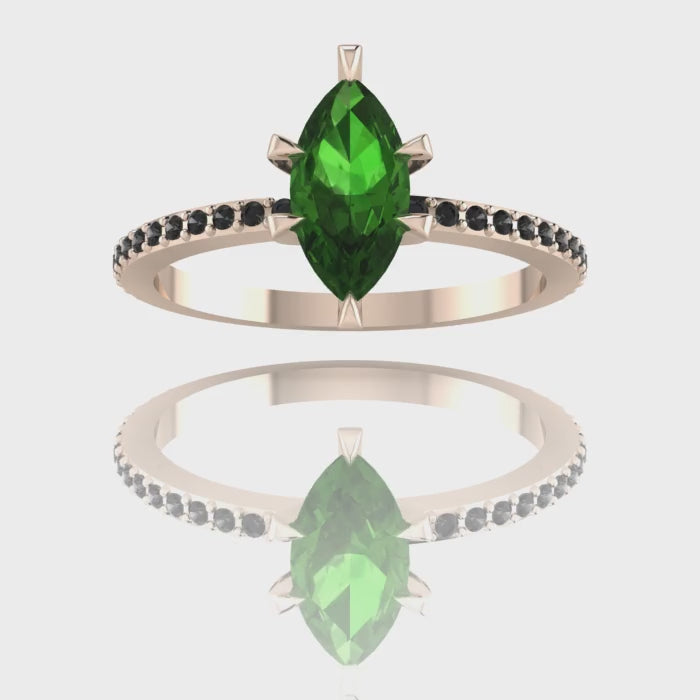 A 360-degree video of the Amoret green tourmaline engagement ring in 18ct rose gold. The footage highlights the deep green facets of the marquise tourmaline and the dark sparkle of the black diamond shoulders.