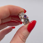 textured silver ring with a purple sapphire set in gold movie