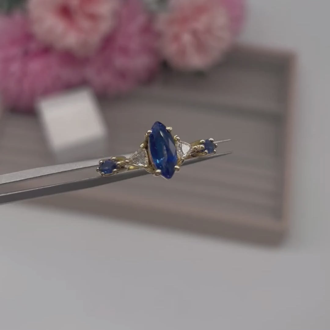 Video of the Maisie marquise blue sapphire and diamond engagement ring in 18ct recycled yellow gold — handmade in London by Nude Jewellery