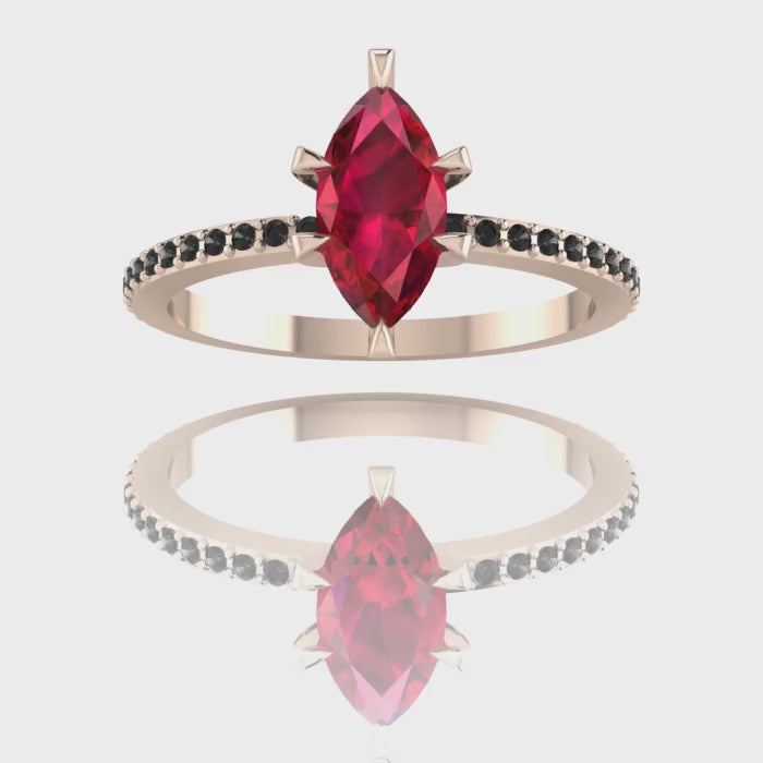 A 360-degree video of the Amoret ruby ring in 18ct rose gold. The footage showcases the rich red hues of the marquise ruby contrasted against the unconventional sparkle of the black diamond shoulders as the ring rotates.