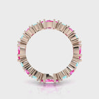 A 360-degree video of the Fire and Ice eternity ring in 18ct rose gold. The footage shows the light catching the pale blue marquise-cut aquamarines and vibrant pink brilliant-cut sapphires as the band rotates, highlighting the rhythmic, architectural cluster and the warm glow of the rose gold.