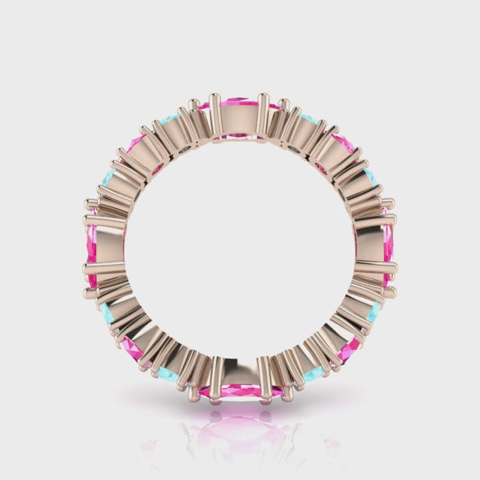 A 360-degree video of the Fire and Ice eternity ring in 18ct rose gold. The footage shows the light catching the pale blue marquise-cut aquamarines and vibrant pink brilliant-cut sapphires as the band rotates, highlighting the rhythmic, architectural cluster and the warm glow of the rose gold.
