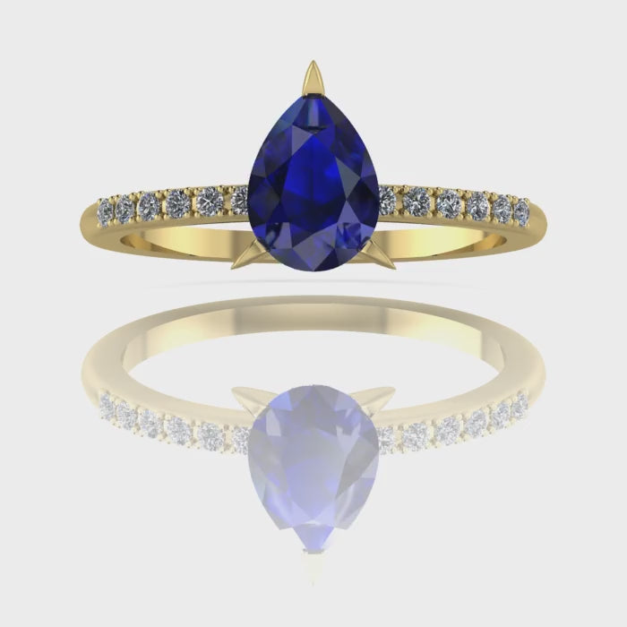 Video of the Calista blue sapphire ring in 18ct yellow gold, capturing the velvety midnight-blue shimmer of the pear centre stone and its sparkling white diamond shoulders.