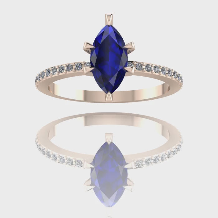 A 360-degree video of the Amoret engagement ring in 18ct rose gold. The footage showcases the rich blue hues of the central marquise sapphire and the sparkle of the brilliant-cut diamond shoulders as the band rotates.