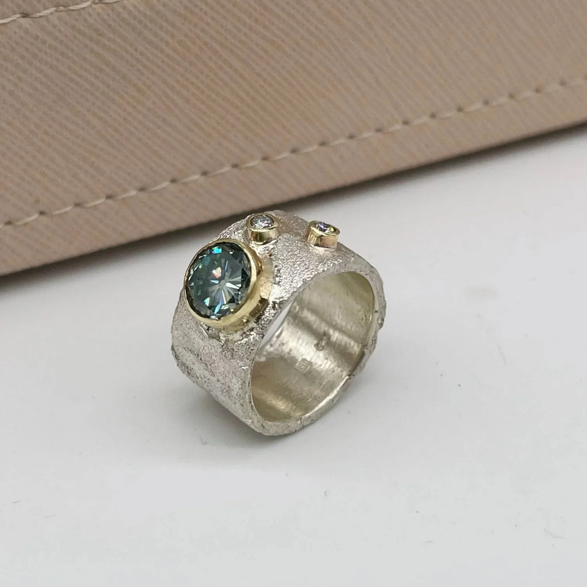 Side view of the Rivda moissanite and diamond ring showing its mixed-metal band and gold settings