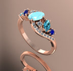 Angled shot showing the wave-inspired 18ct rose gold setting and the intricate cluster of blue gemstones and diamonds.