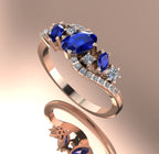 Side view of the 18ct rose gold Atlantis Storm sapphire and diamond ring, showing the hallmark and setting structure.